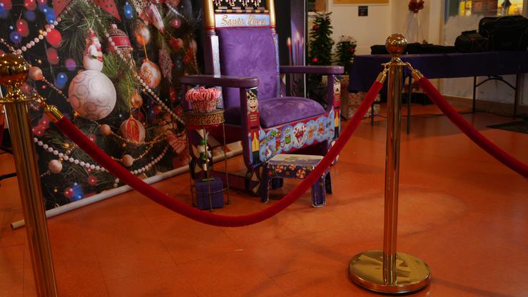 Custom Santa Albert chair and brass and red velvet stanchions.